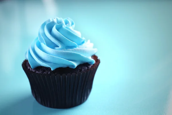 Chocolate cupcake on blue background — Stock Photo, Image