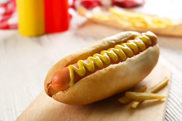 Perro caliente con papas fritas sobre papel artesanal —  Fotos de Stock