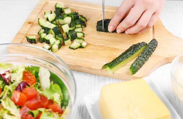 Mani femminili che tagliano verdure per insalata, a cucina — Foto Stock