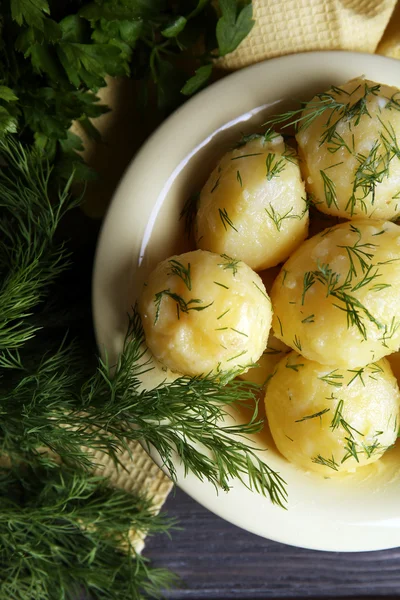 Kokt potatis med greener i skål på bordet på nära håll — Stockfoto