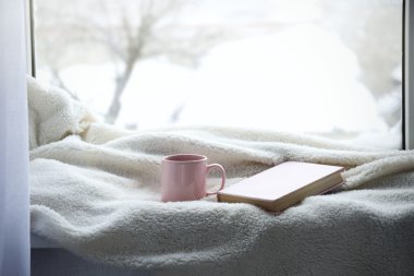 Fincan çay, kitap ve sıcak battaniye
