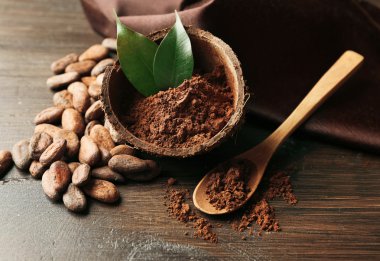 Aromatik kakao tozu ve ahşap zemin üzerine yeşil yaprak kase, yakın çekim