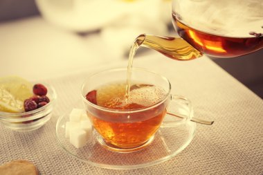 Çay Kupası ve kanepenin yanındaki masada su ısıtıcısı