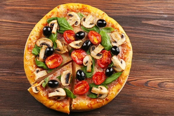 Нарізана смачна піца з овочами на дерев'яному столі — стокове фото