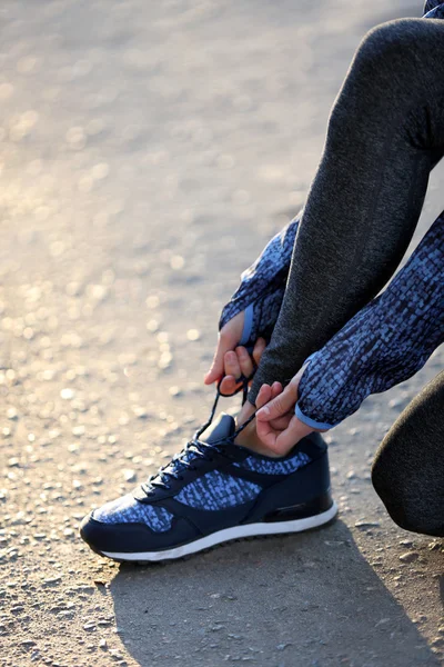 Woman in sportswear tying shoelaces — Stock Photo, Image