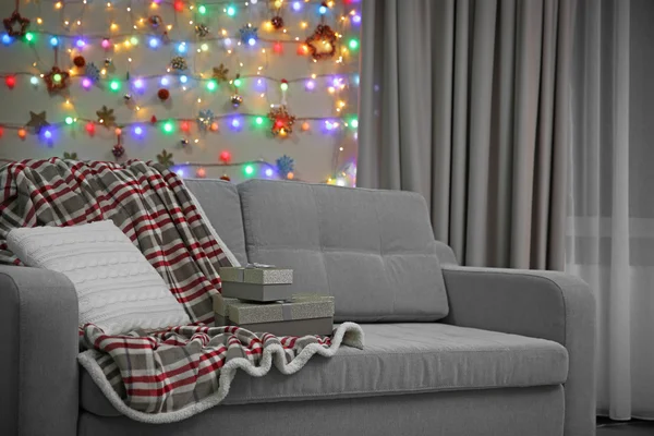 Серый диван с подушкой и подарками — стоковое фото