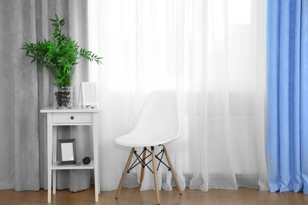 Белый стол с зеленым растением — стоковое фото
