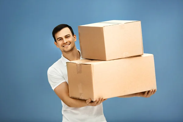 Чоловік тримає купу картонних коробок — стокове фото