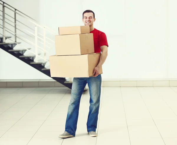 Hombre sosteniendo pila de cajas de cartón — Foto de Stock