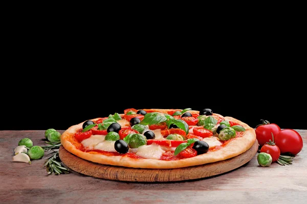 Délicieuse pizza au fromage et légumes sur fond noir — Photo