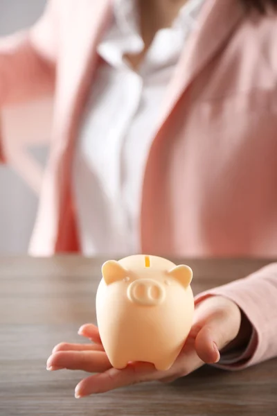 Mulher segurando na mão porquinho banco — Fotografia de Stock