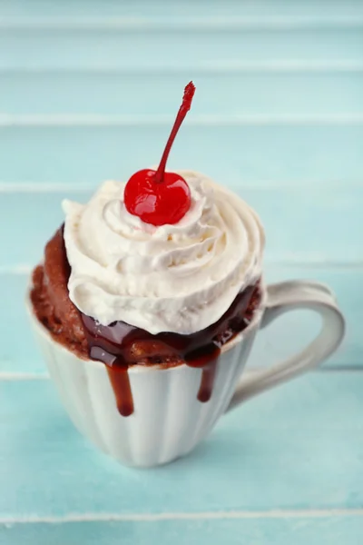 Gâteau tasse chocolat à la crème et cerise sur fond de bois bleu — Photo