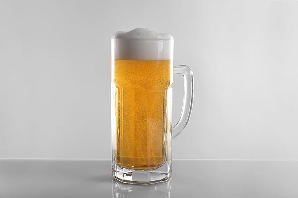 Glass of lager beer on light grey background — Stock Photo, Image