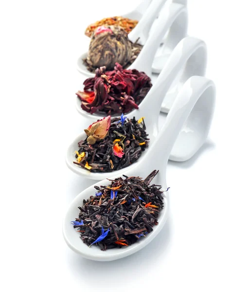 Verschiedene Arten von trockenem Tee in Keramiklöffeln, isoliert auf weißem — Stockfoto