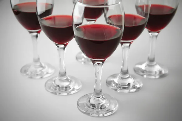 Очки красного вина на белом столе крупным планом — стоковое фото