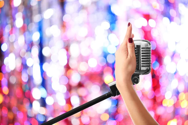 Mão feminina segurando microfone — Fotografia de Stock
