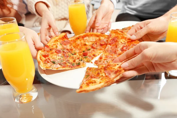 Amigos mãos segurando pizza quente, de perto — Fotografia de Stock