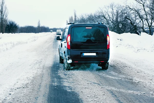 Carro dirigindo na estrada nevada — Fotografia de Stock