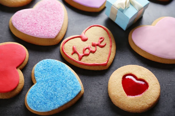 Assortment of love cookies with gift on blue wooden table background