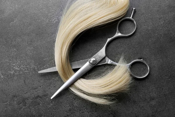 Ножницы с прядью светлых волос — стоковое фото