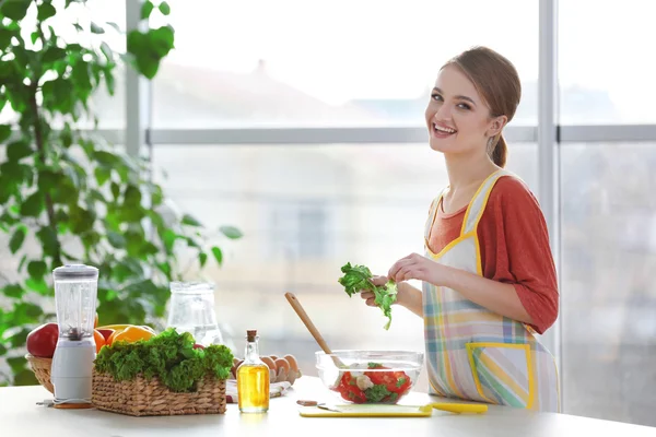 Junge Frau bereitet Gemüsesalat zu — Stockfoto