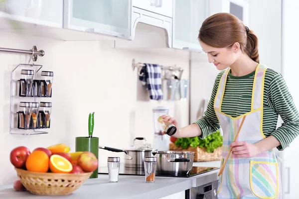 Jonge vrouw koken in keuken — Stockfoto