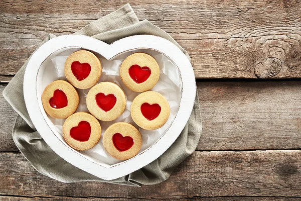 Sortiment lásky cookies v poli látkou na dřevěné pozadí, detail — Stock fotografie