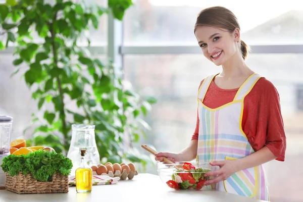 Jeune femme préparant une salade de légumes — Photo