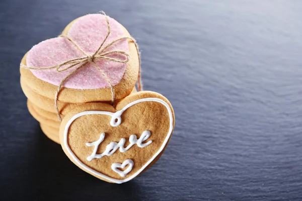 Galletas de amor rosadas sobre fondo oscuro, primer plano —  Fotos de Stock