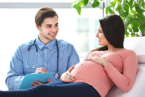 Gravid kvinna med läkare — Stockfoto