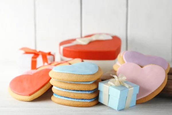 Biscuits coeur Saint-Valentin avec des boîtes cadeaux sur fond en bois — Photo