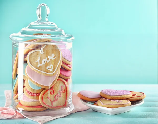 Assortment of love cookies in jar on blue background — Stock Photo, Image