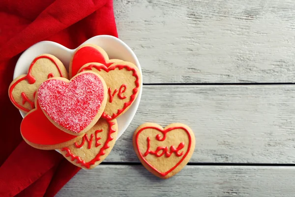 Surtido de galletas de amor con paño rojo sobre fondo de mesa de madera gris — Foto de Stock