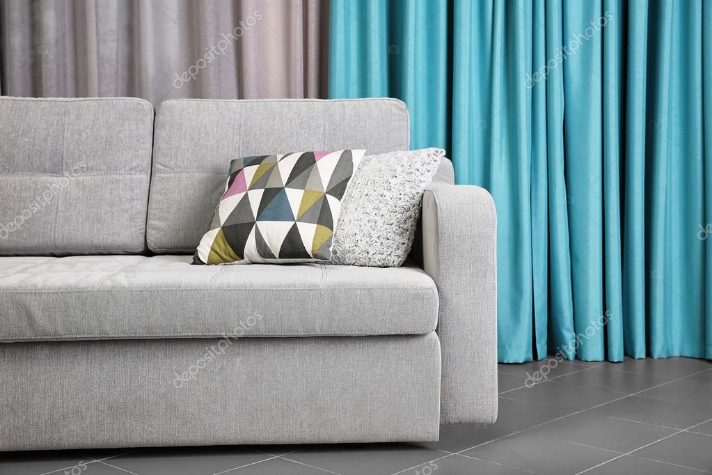 Grey sofa against curtains Stock Photo by ©belchonock 102147038