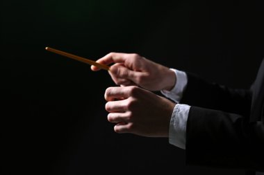 Siyah arka planda, baton ile yönetmenlik müzik iletken yakın çekim