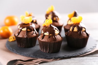 Dilim mandalina ve kayrak plaka üzerinde açık ahşap renkli çikolata ile lezzetli kek