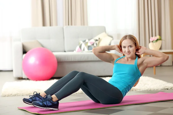 Sportswoman doing exercises on a mat — Stock Photo, Image