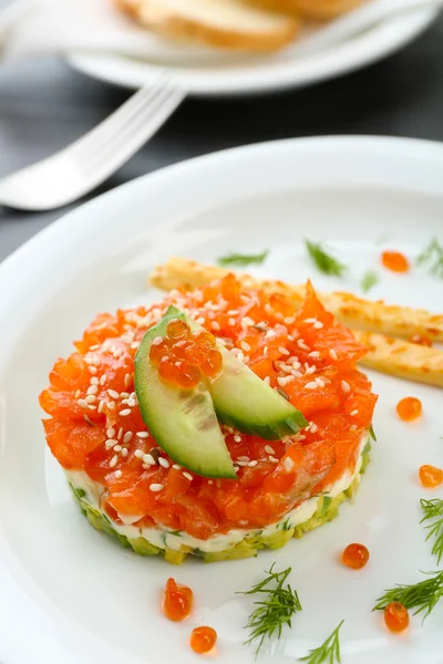 Sarro fresco con salmón, aguacate, pepino y caviar rojo en plato blanco, primer plano —  Fotos de Stock