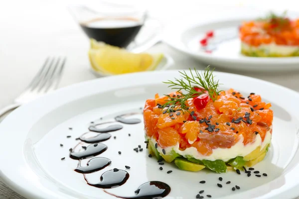 Fresh tartar with salmon, avocado and soy sauce on white plate, close up Royalty Free Stock Photos