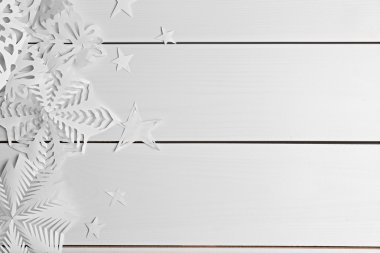 paper snowflakes on wooden background clipart