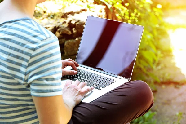 Homem trabalhando com laptop no parque — Fotografia de Stock