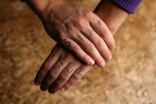 Tattoo inscriptions on male fingers — Stock Photo, Image