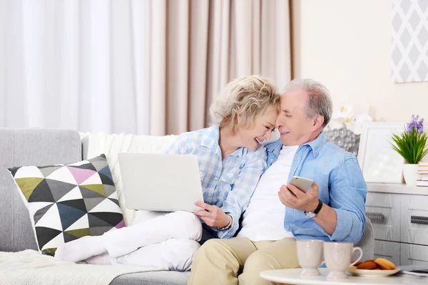 Ouder paar zitten samen met laptop — Stockfoto