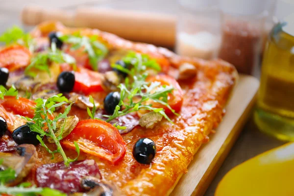 Rektangel läcker pizza och grönsaker på bordet, närbild — Stockfoto