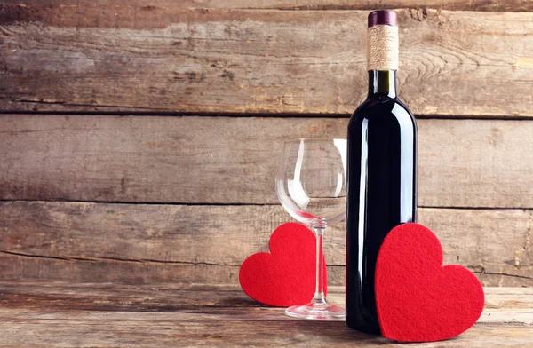 Κόκκινες καρδιές με μπουκάλι κρασί και γυαλί — Φωτογραφία Αρχείου