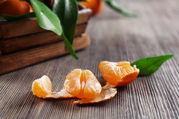 Mandarine fraîche pelée sur table en bois, gros plan — Photo