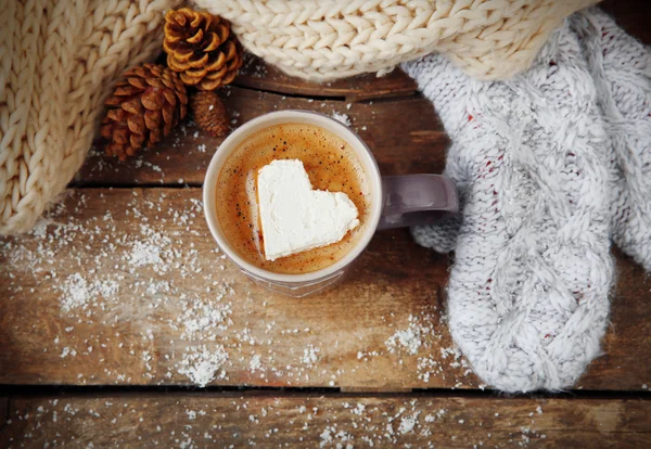 Šálek kávy s marshmallow na dřevěném stole — Stock fotografie