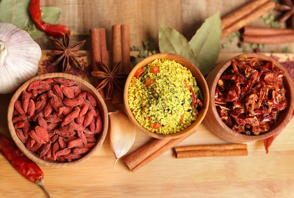 Diverse specerijen op houten tafel, bovenaanzicht — Stockfoto