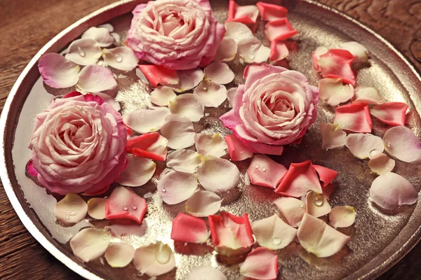 Розовые и желтые лепестки роз в серебряной чаше — стоковое фото