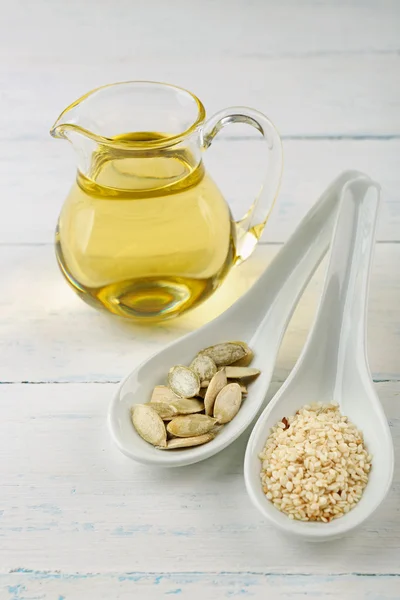 Pompoen en sesam zaden met olieverf op houten tafel — Stockfoto